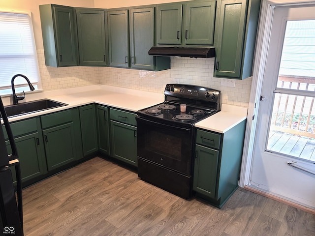 kitchen with hardwood / wood-style flooring, green cabinets, sink, and black / electric stove