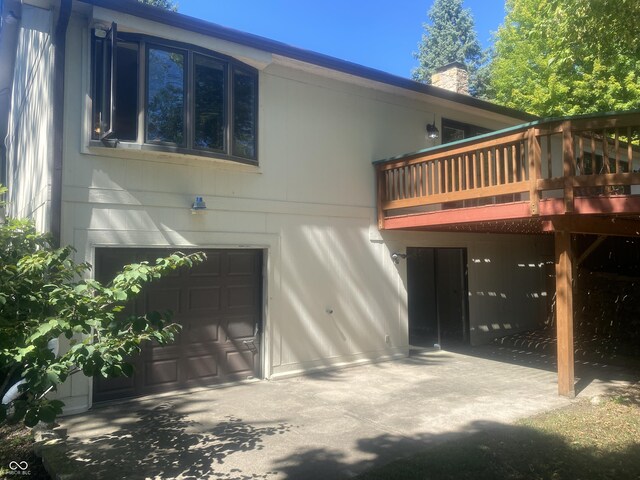 back of property featuring a garage and a wooden deck