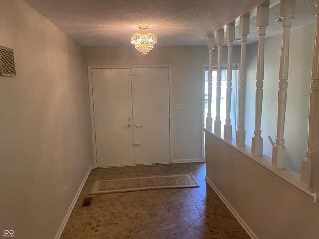 entrance foyer with a textured ceiling and an inviting chandelier