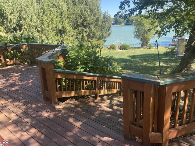 deck featuring a water view and a lawn