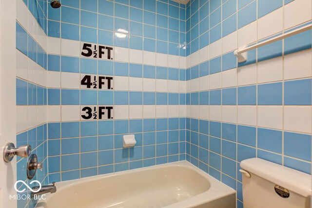 bathroom featuring toilet and washtub / shower combination