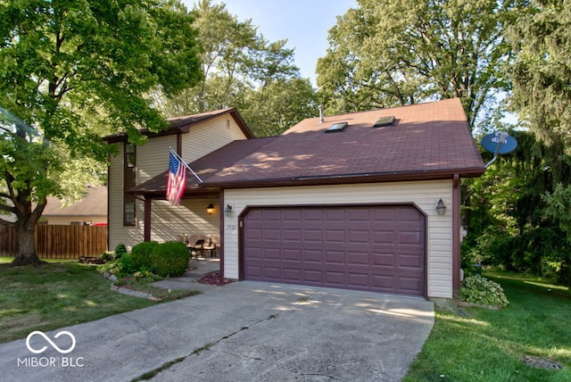 view of front of house with driveway, a front lawn, fence, roof with shingles, and an attached garage