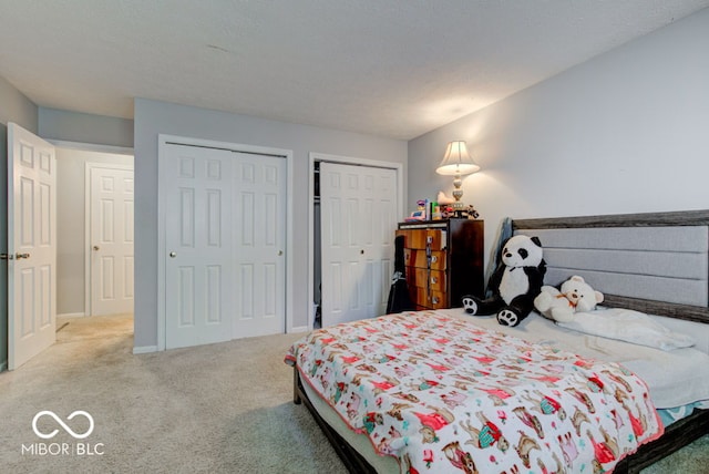 bedroom with carpet flooring and two closets