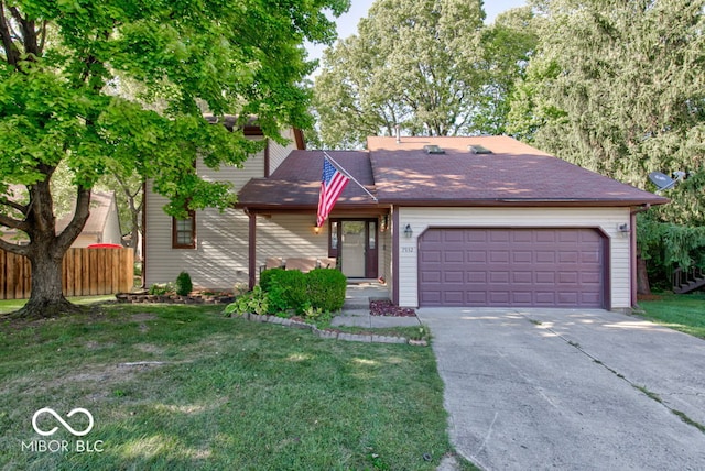 view of front facade featuring a front yard, fence, a garage, and driveway