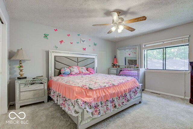 bedroom featuring a textured ceiling, ceiling fan, and carpet