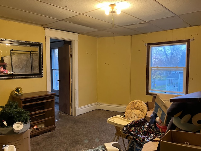 misc room featuring dark colored carpet and a paneled ceiling