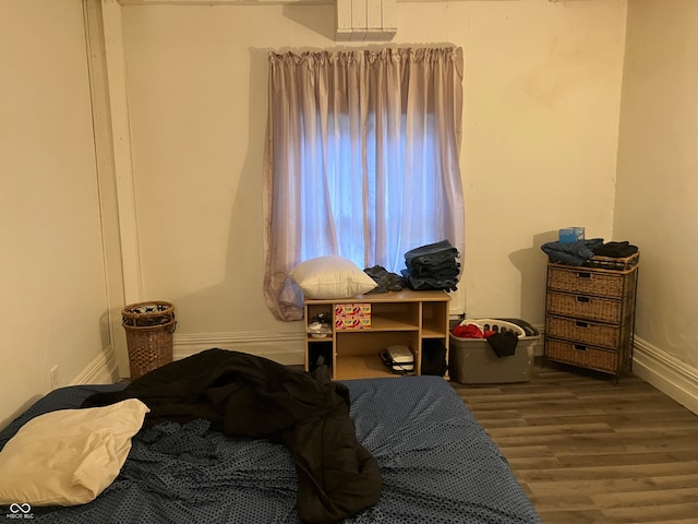 bedroom with dark hardwood / wood-style flooring