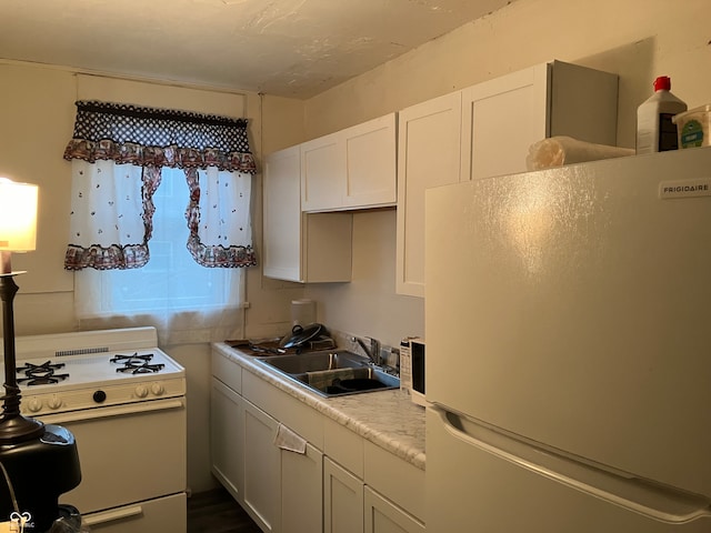 kitchen featuring white cabinetry, sink, and white appliances