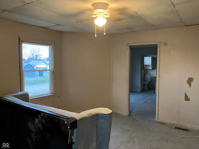 unfurnished bedroom with a drop ceiling and ceiling fan