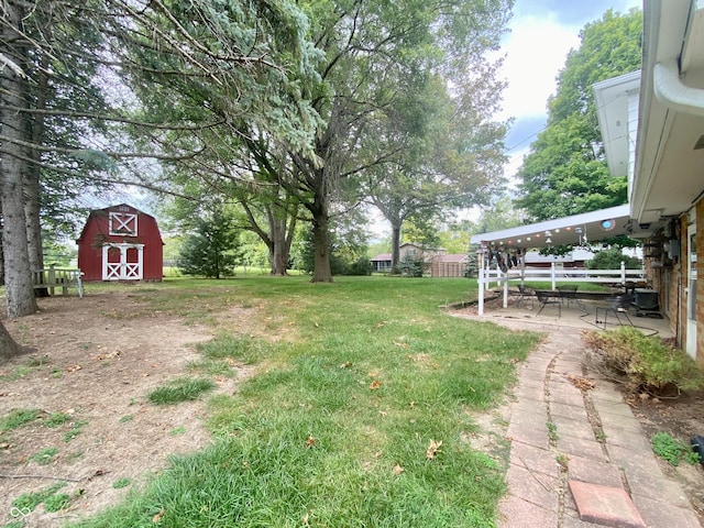 view of yard featuring a storage unit and a patio area