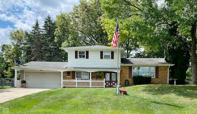 split level home with covered porch, a garage, and a front lawn