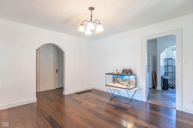 532 E Mills Ave, Indianapolis, IN 46227 - unfurnished room featuring visible vents, wood finished floors, arched walkways, baseboards, and a chandelier