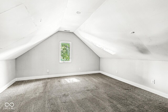 bonus room with carpet flooring and vaulted ceiling