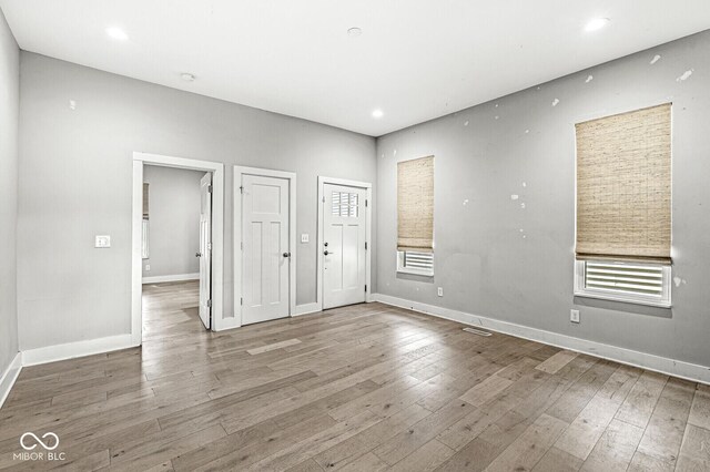 unfurnished bedroom with light wood-type flooring and multiple windows