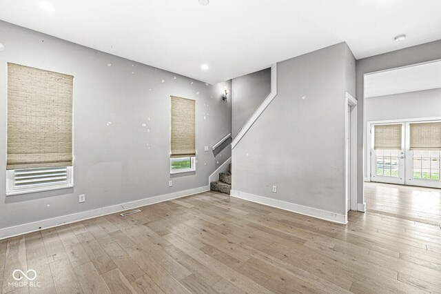 empty room with a wealth of natural light and light hardwood / wood-style floors