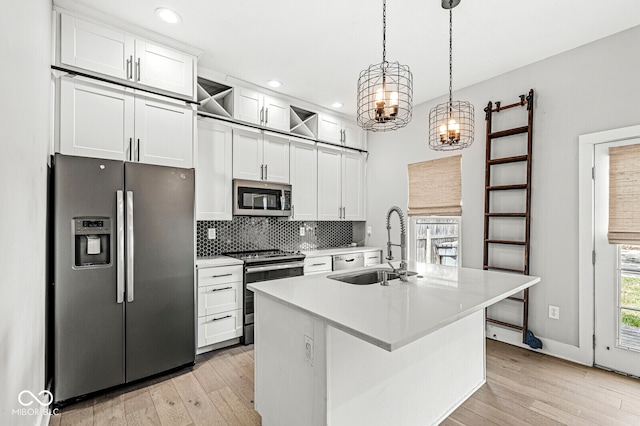 kitchen featuring an island with sink, stainless steel appliances, light wood-type flooring, and white cabinets