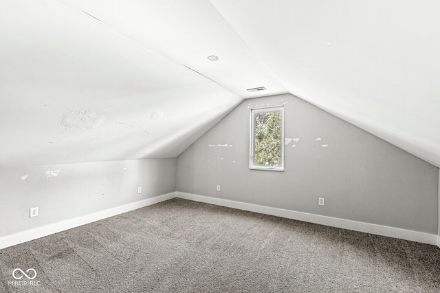 bonus room with carpet flooring and vaulted ceiling