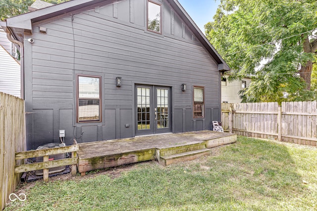 back of property featuring a deck and a lawn