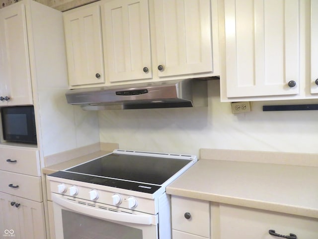 kitchen with white stove and white cabinetry