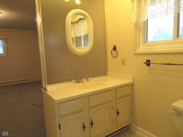 bathroom featuring vanity, a baseboard heating unit, and toilet