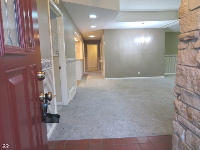 hallway with carpet flooring and a notable chandelier