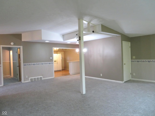 interior space featuring light colored carpet and lofted ceiling