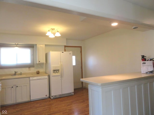 kitchen featuring a sink, wood finished floors, white appliances, white cabinets, and light countertops