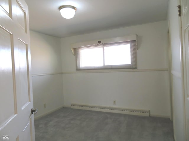 unfurnished room featuring baseboard heating and carpet flooring