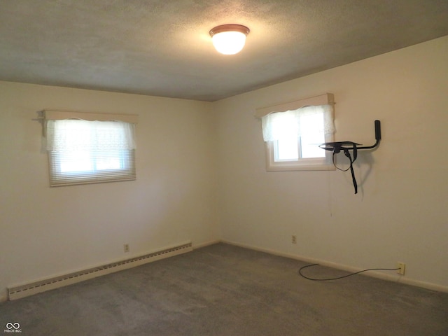 carpeted empty room with a baseboard heating unit, baseboards, and a textured ceiling