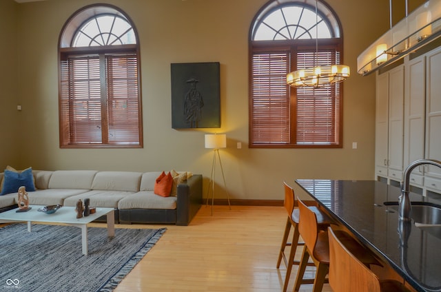 living room with sink, a chandelier, and light hardwood / wood-style floors