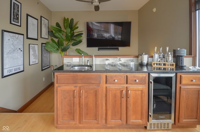 kitchen with beverage cooler, light hardwood / wood-style flooring, sink, and ceiling fan