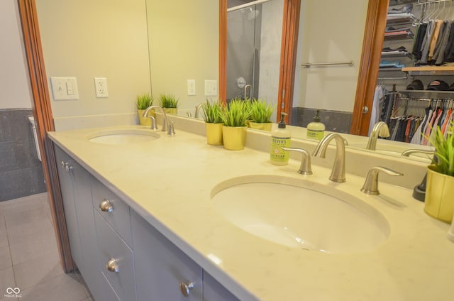 bathroom featuring a shower with door and vanity