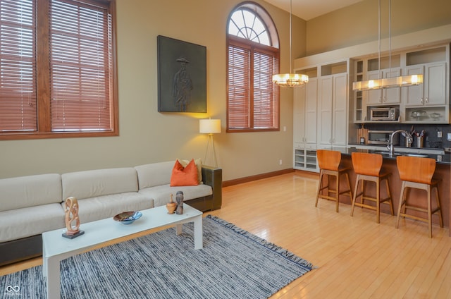 living room with light hardwood / wood-style flooring and an inviting chandelier