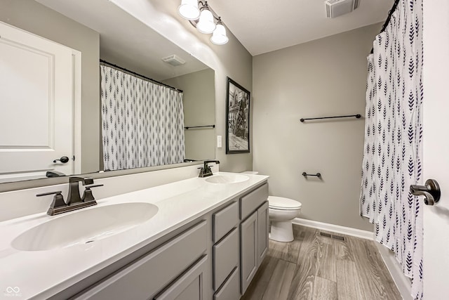 bathroom with visible vents, a sink, and wood finished floors