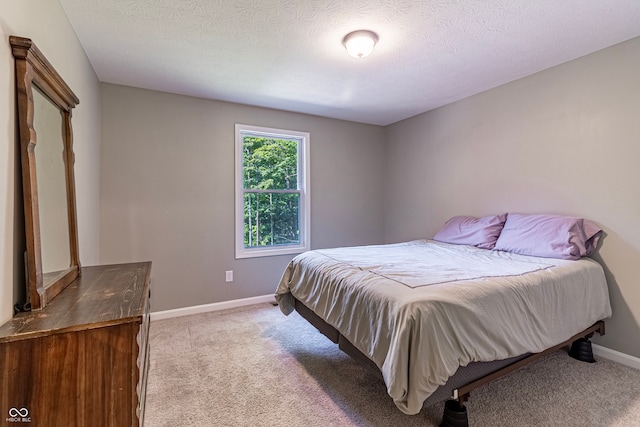 bedroom featuring light carpet and a textured ceiling