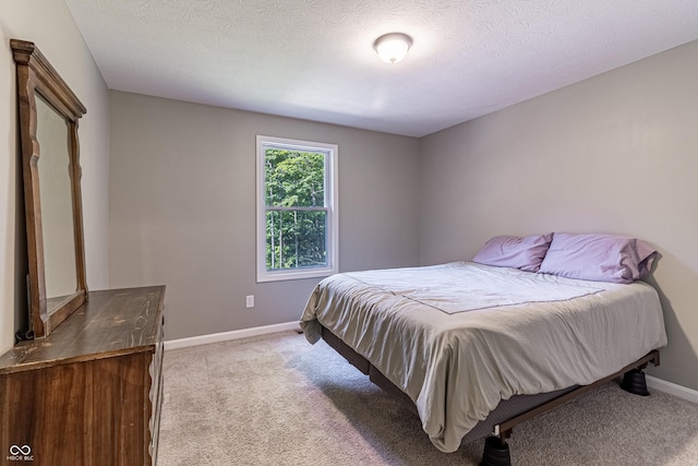 carpeted bedroom featuring a textured ceiling and baseboards