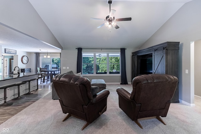 carpeted living area featuring high vaulted ceiling, baseboards, and ceiling fan with notable chandelier