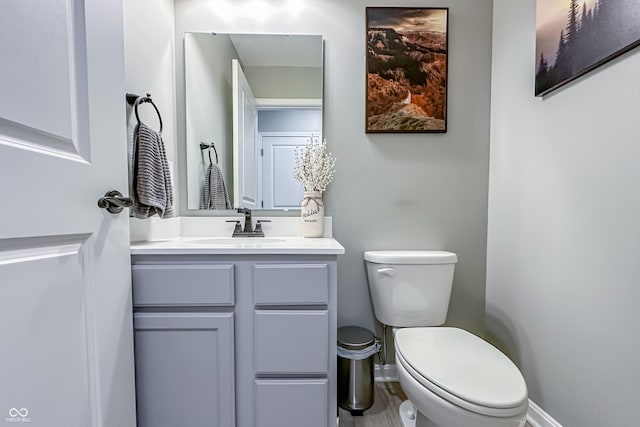 bathroom featuring vanity, toilet, and baseboards