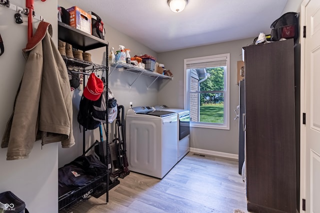 washroom with washer and clothes dryer and light hardwood / wood-style flooring