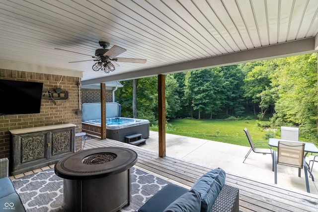 view of patio featuring a hot tub, ceiling fan, a deck, and a fire pit