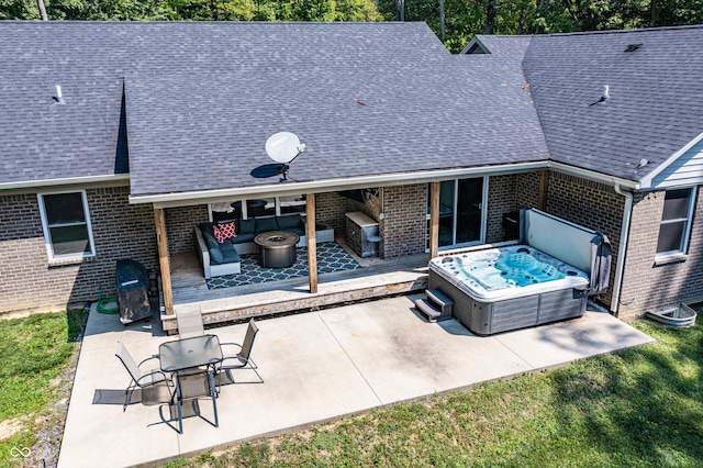 back of house with a deck, a patio area, and a hot tub