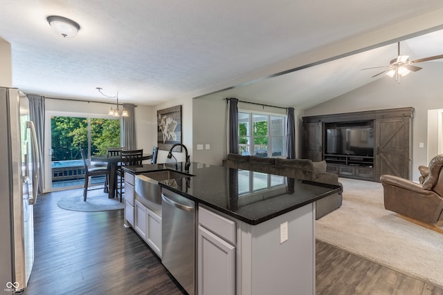 kitchen featuring vaulted ceiling, white cabinets, ceiling fan with notable chandelier, dark hardwood / wood-style flooring, and stainless steel appliances