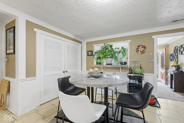 tiled dining room featuring a textured ceiling