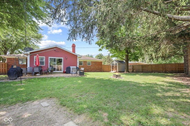 view of yard featuring an outdoor fire pit, a patio area, and a shed