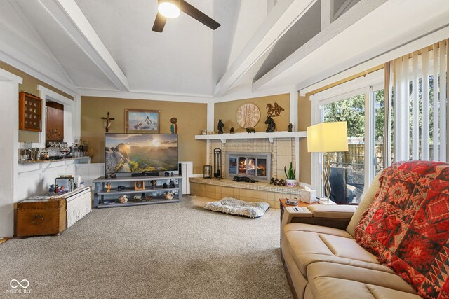 carpeted living room featuring a tiled fireplace, vaulted ceiling, and ceiling fan