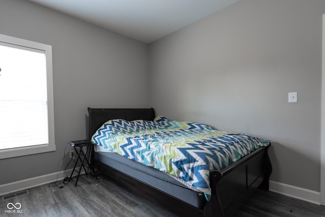 bedroom with dark hardwood / wood-style flooring