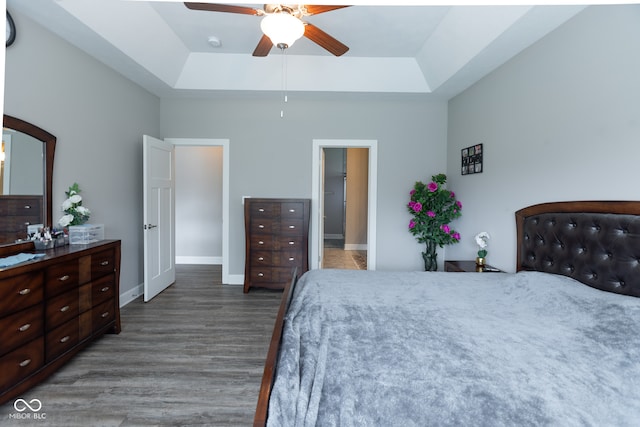 bedroom featuring ceiling fan, hardwood / wood-style flooring, and a tray ceiling