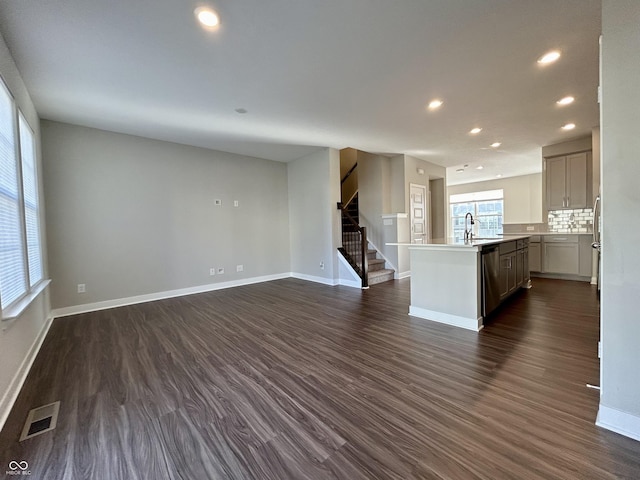 unfurnished living room featuring dark hardwood / wood-style floors and sink