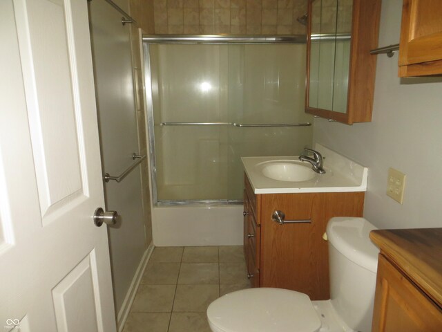 full bathroom with tile patterned floors, toilet, combined bath / shower with glass door, and vanity