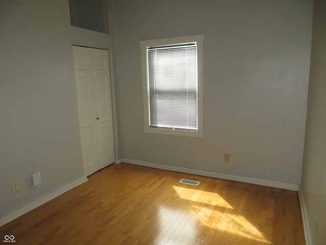 unfurnished bedroom featuring light hardwood / wood-style flooring and a closet